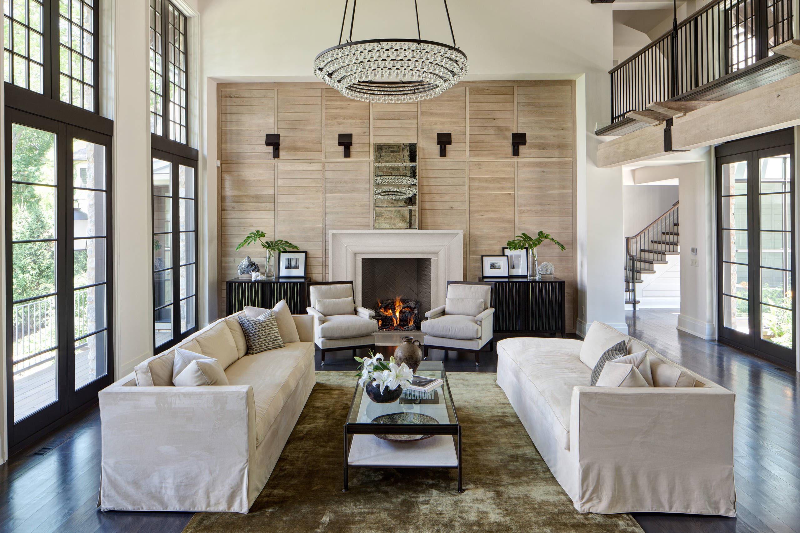 A spacious living room with a fireplace mantel and chandelier.