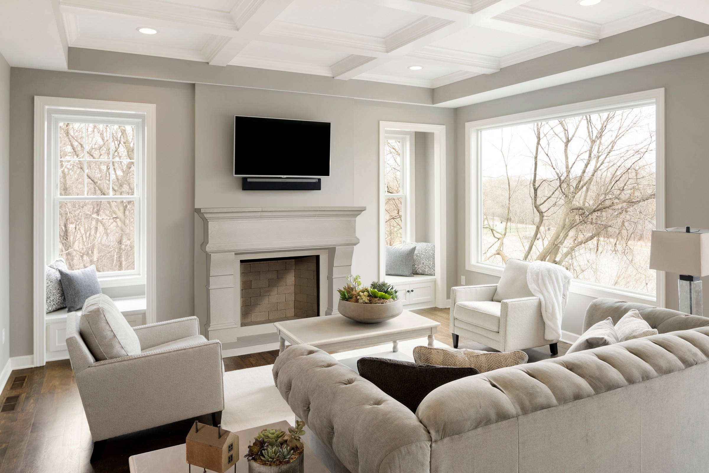 A living room with white furniture and a fireplace mantel.