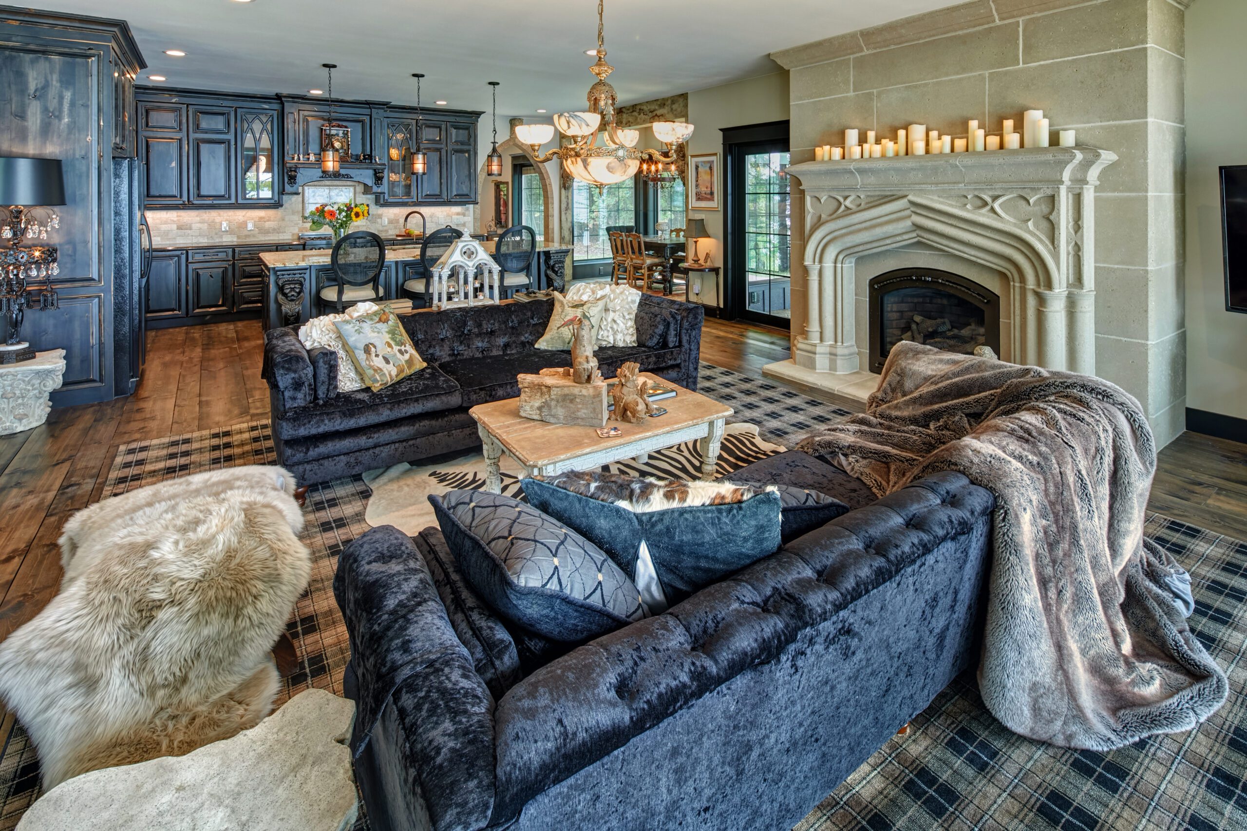 A living room with black furniture, a fireplace, and a mantel.